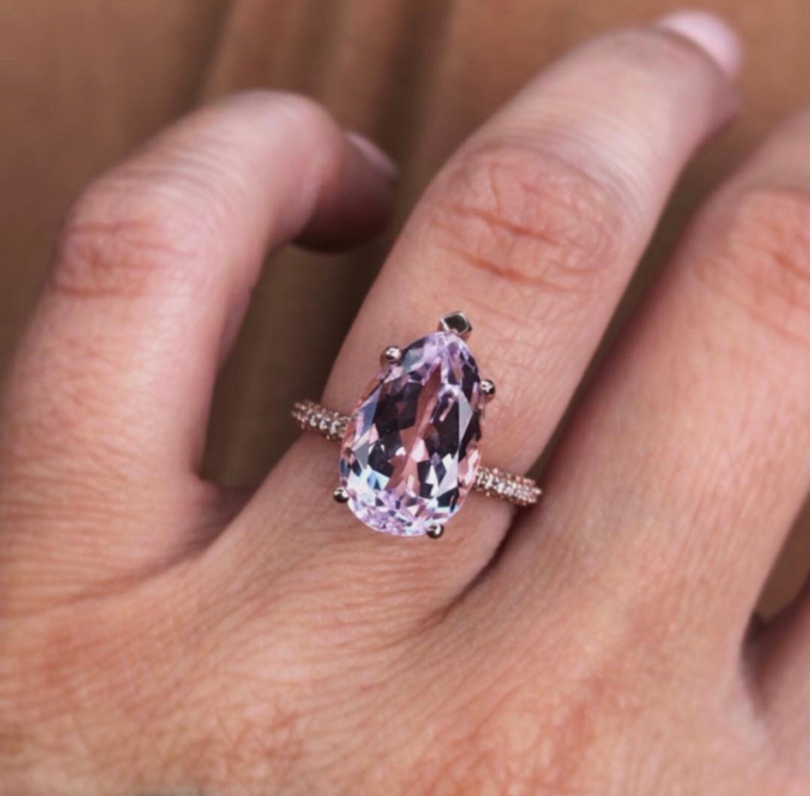 “Kunzite Halo Ring on hand – pear shape lavender kunzite with side diamonds”